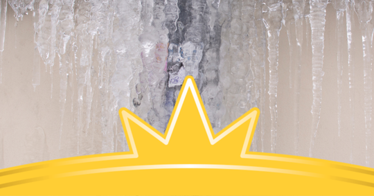 Icicles hang from a roof over a yellow banner, likely indicating roofing issues.