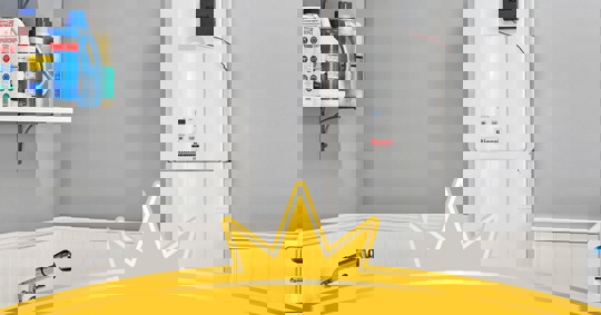 A laundry room corner features a modern tankless water heater and laundry supplies.