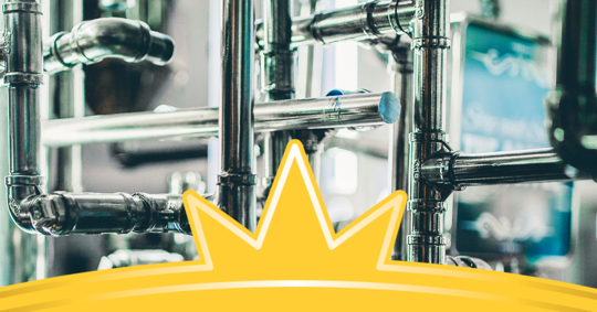 a network of industrial metal pipes with a vibrant yellow graphic in the foreground.